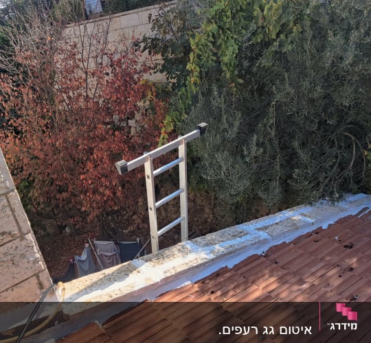 גג עם חומר איטום לבן ליד רעפים אדומים